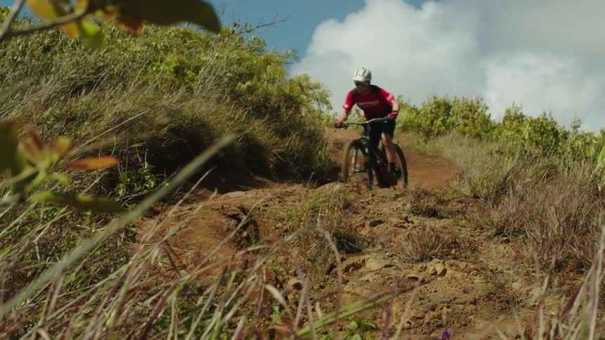 A man speeding down a hillside on a mountain bike