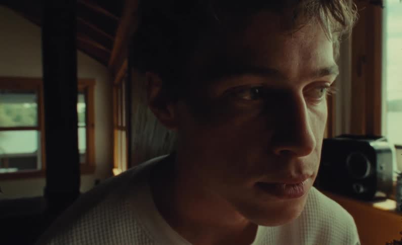 Man sits alone near window thinking