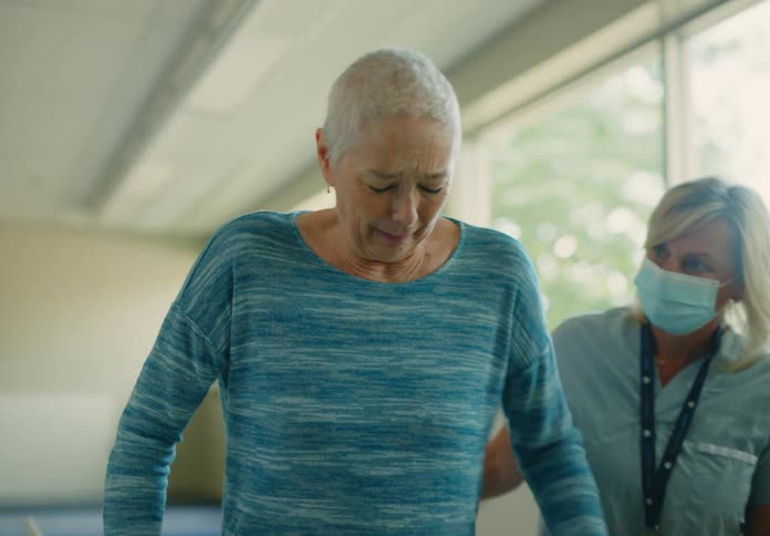 Elderly patient works on gait training under care of physiotherapist