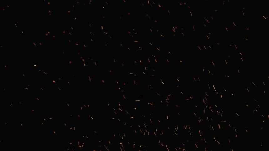 Ashes and sparks flying up into a dark sky