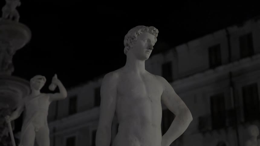 Statues in ruins at night