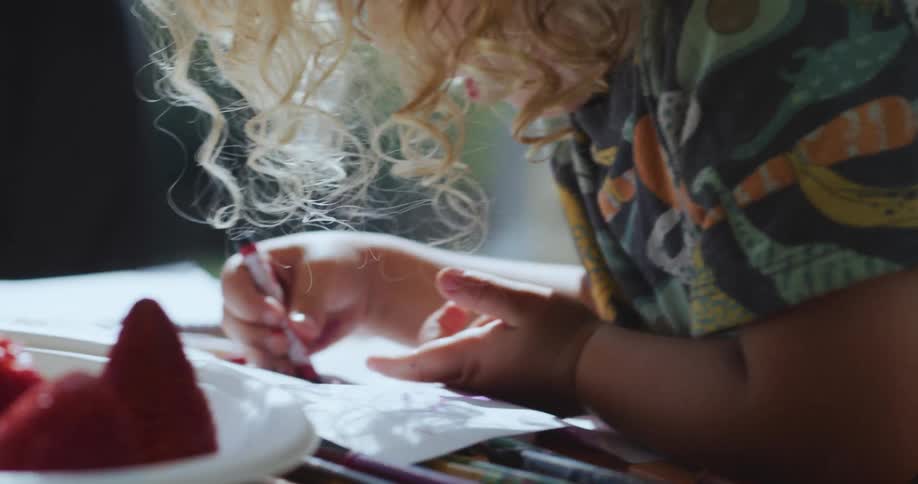 A young child colors outside