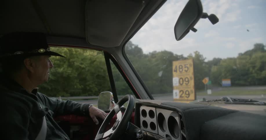 A man sits in his truck at a gas station