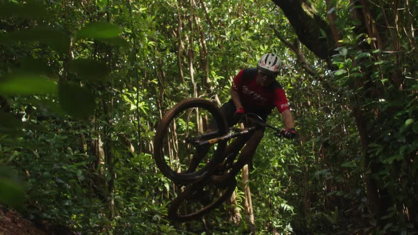 A man jumping a mountain bike in the forest