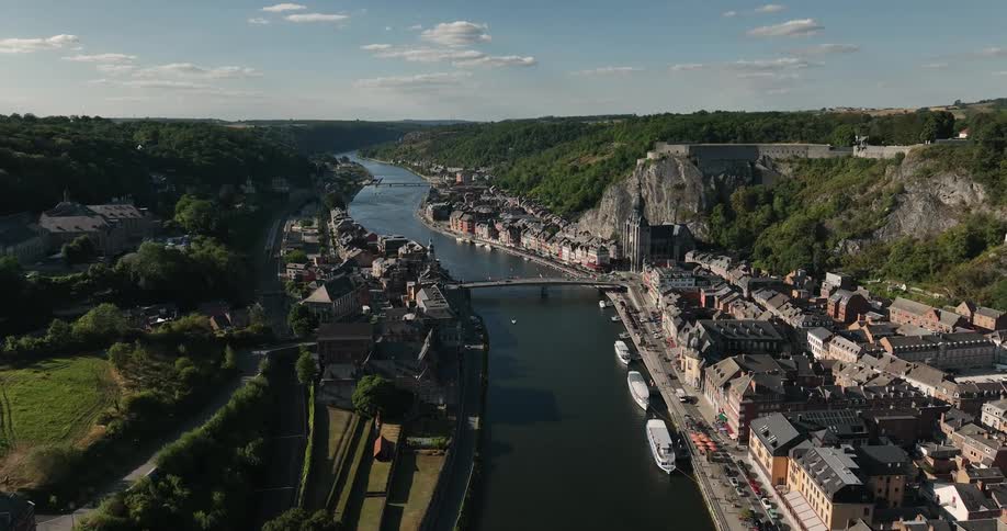 Cathedral sits at base of cliff topped by castle as traffic crosses over nearby bridge