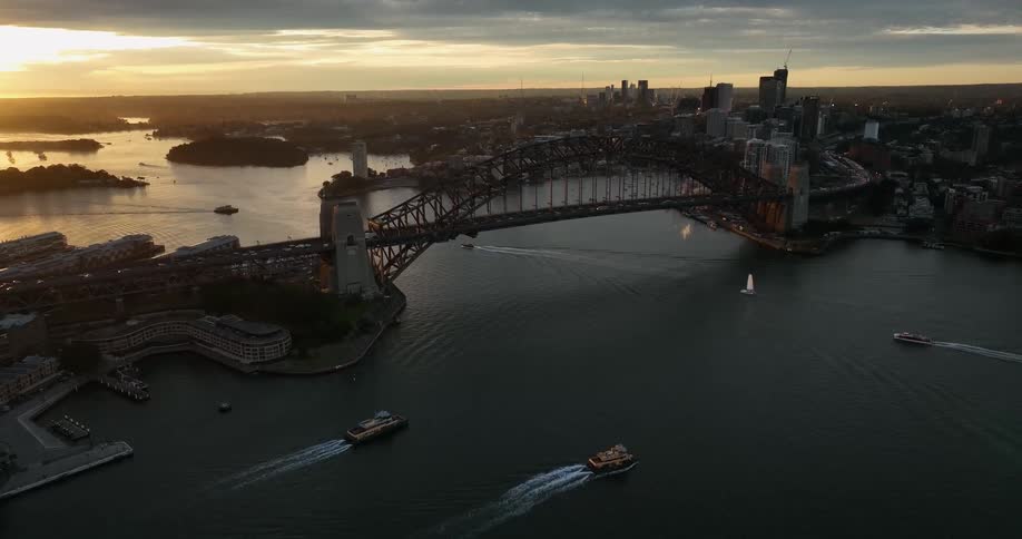 A large bridge spanning a waterway in a metropolis in the evening
