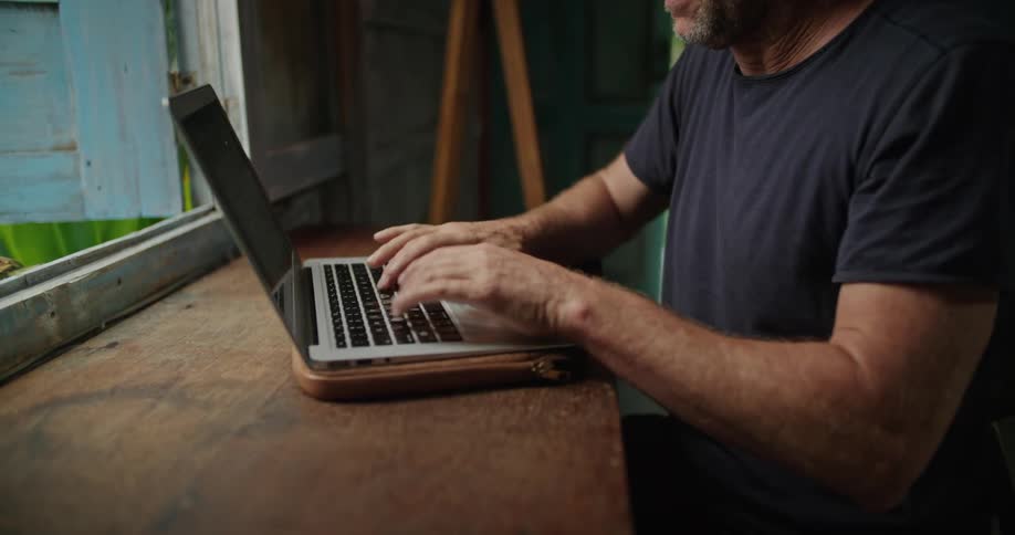 A man is typing on his laptop