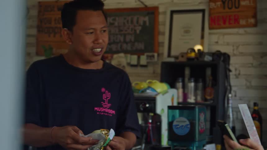 Tourist shows a waiter on a small outdoors cafe a picture on the smartphone