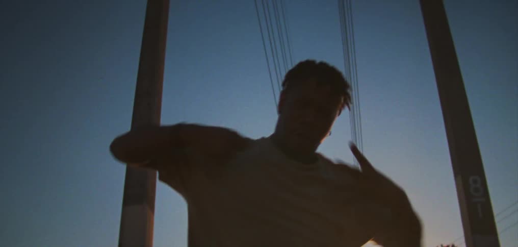 Silhouette of a young man dancing on the countryside at evening