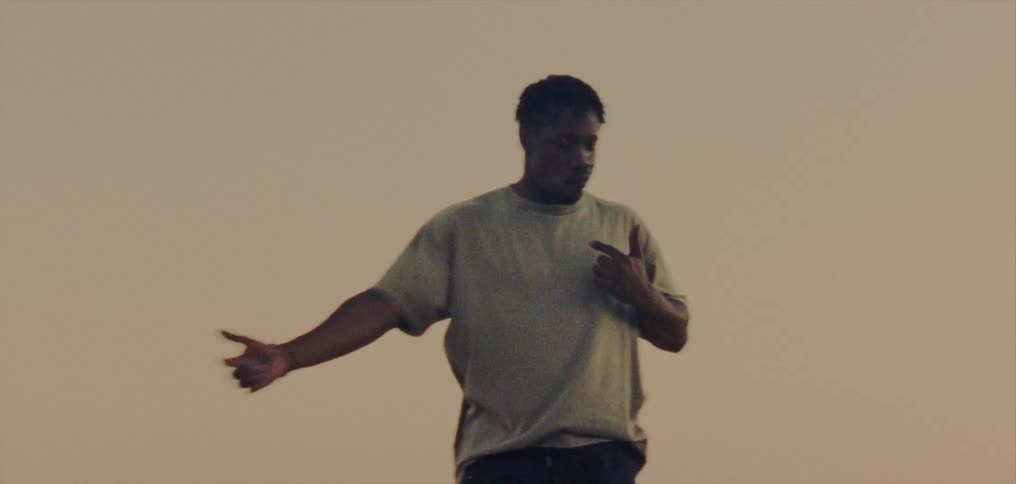 Young man wearing a white shirt dancing at evening
