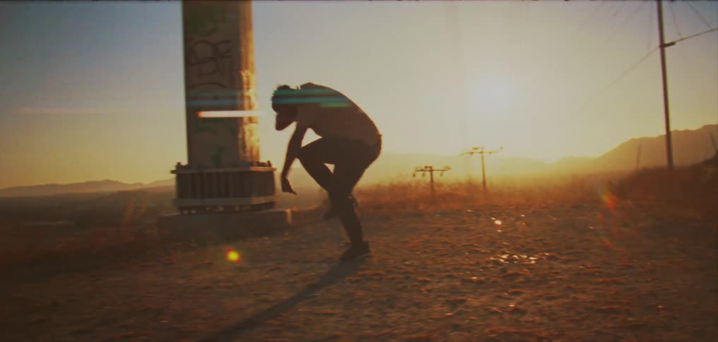 A man is outside dancing passionately on a dirt road