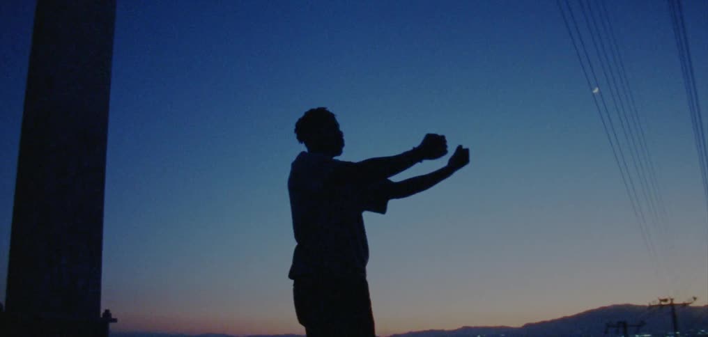A man dances outside at night
