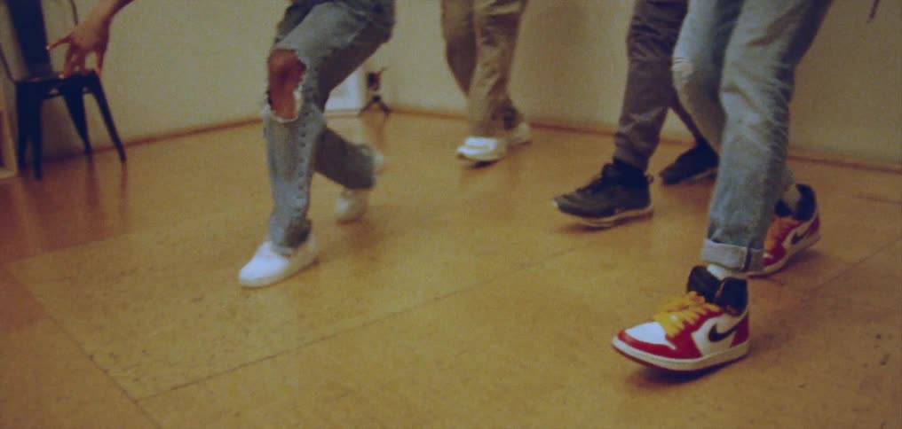 A group of dancers perform a choreographed routine in a studio