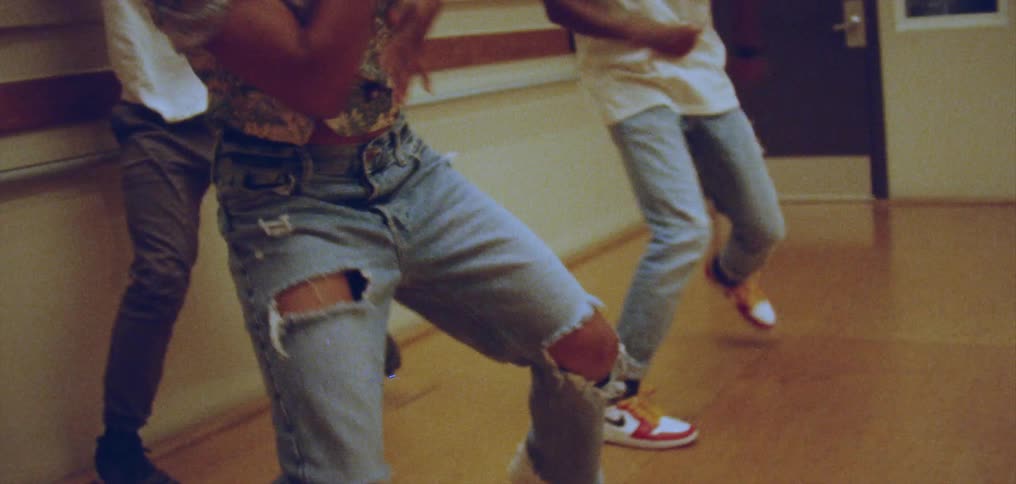 Group of happy people performing a choreographed dance on a room