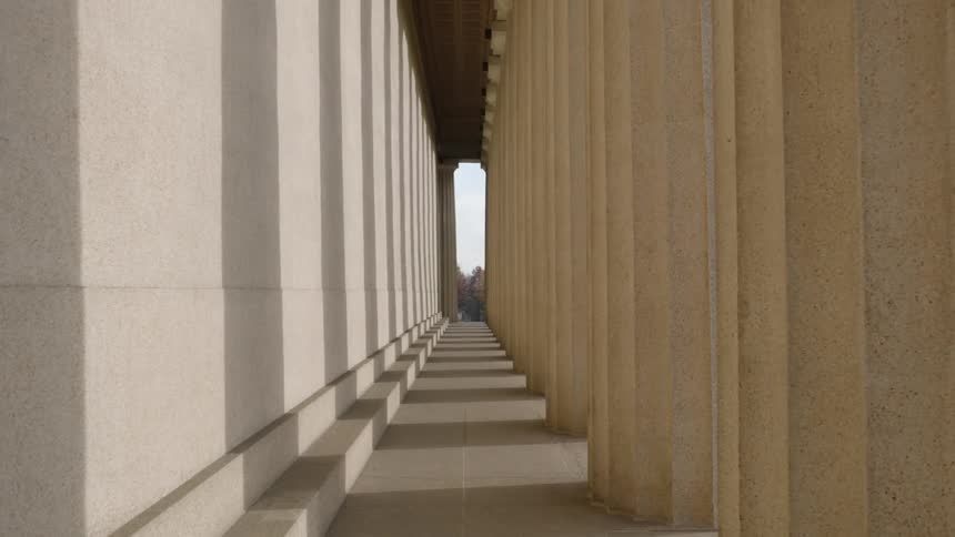 Columns cast shadows against a wall