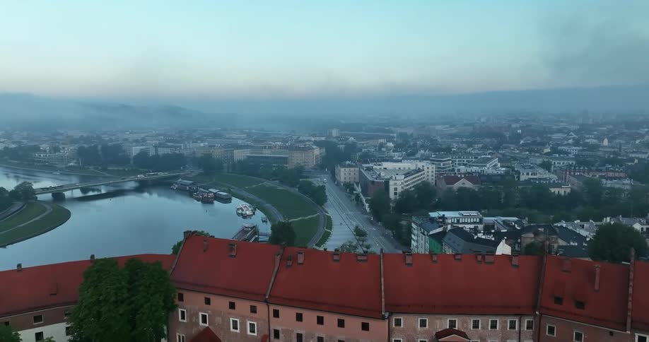 Heavy fog settles over a dense but quaint town along a river
