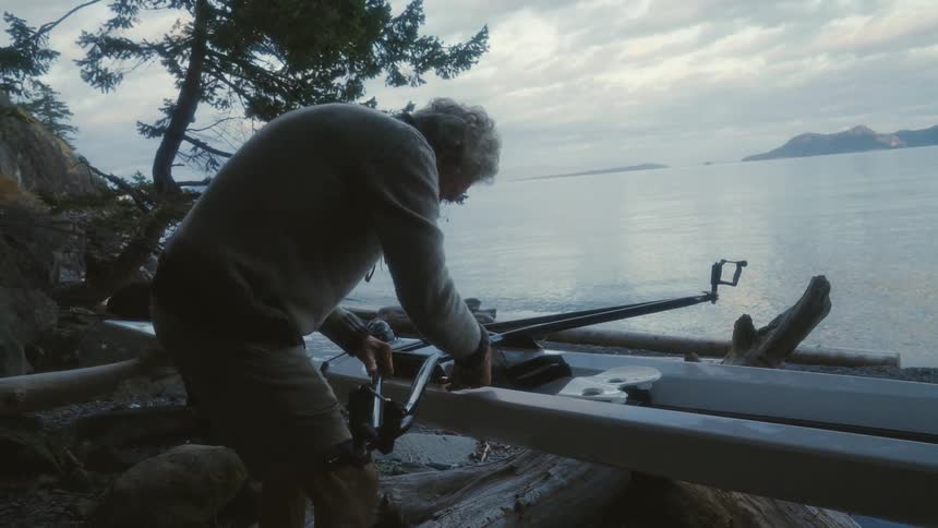 A man using a tool next to a lake