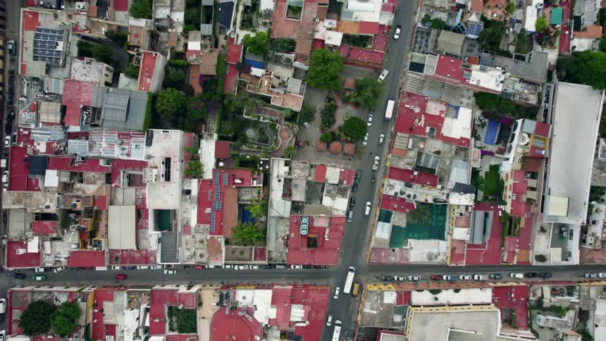 Top down aerial view cars driving on the narrow streets of a latin american town