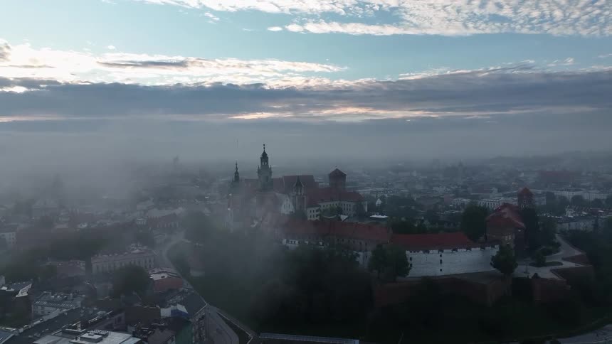 Dense fog settles over a town with historical buildings