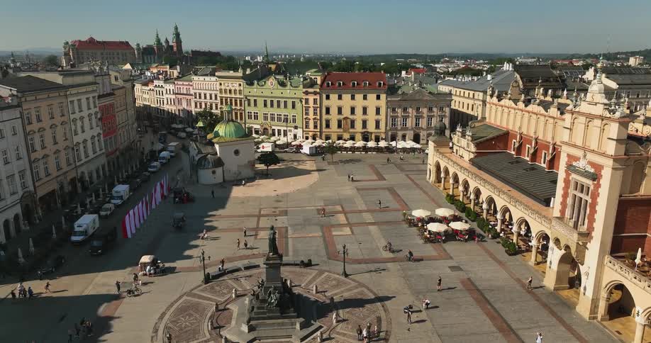 People walk around a monument in a town square