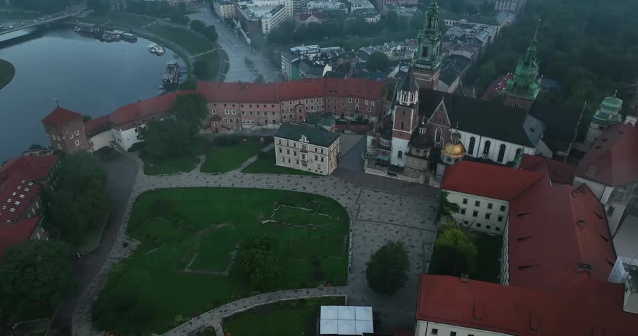 Aerial view of the gardens of an european castle near a river in the evening