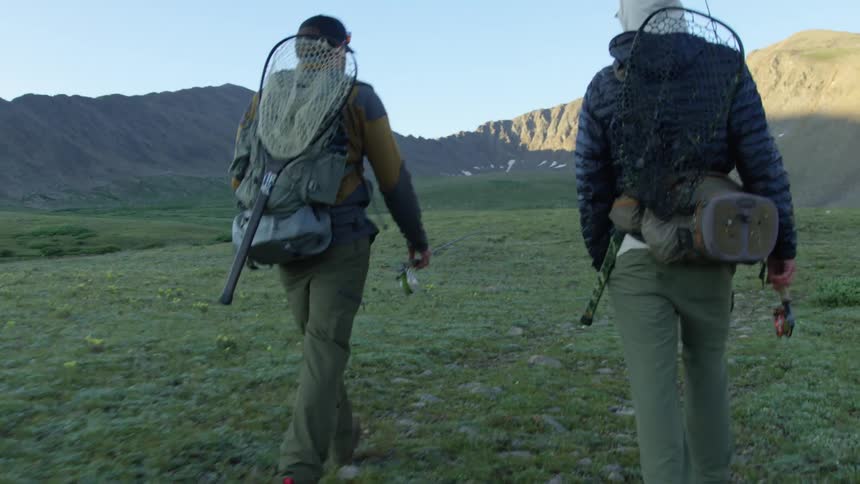 Two men are hiking through a mountainous area