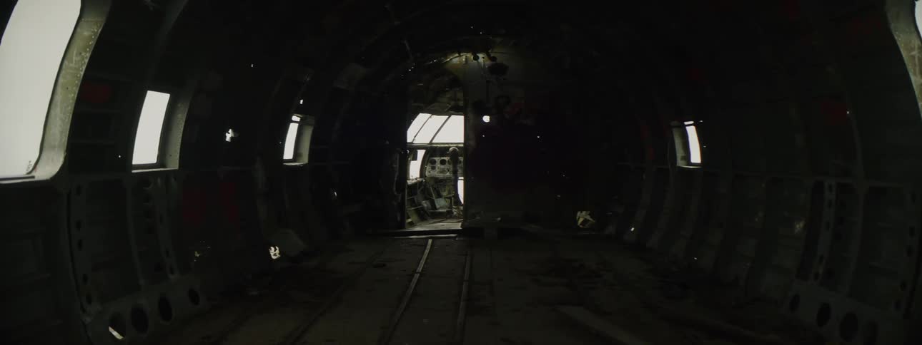Walking on the dark dismantled interior of an abandoned airplane fuselage