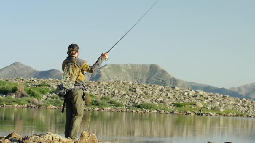 A man throws a fishing line into a lake