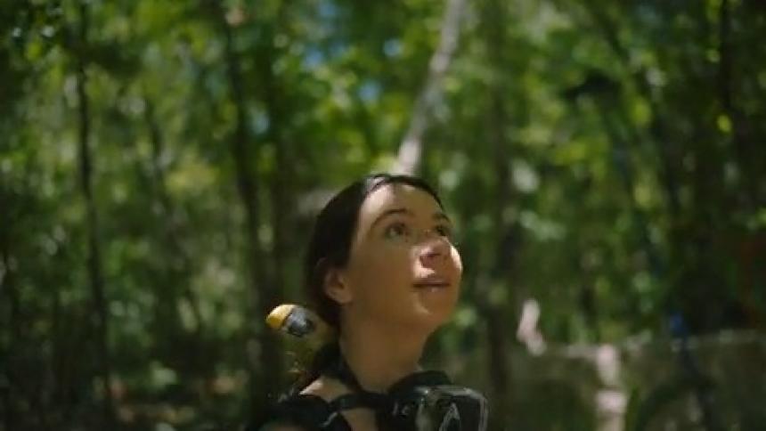 Young woman carrying SCUBA gear hikes through the jungle