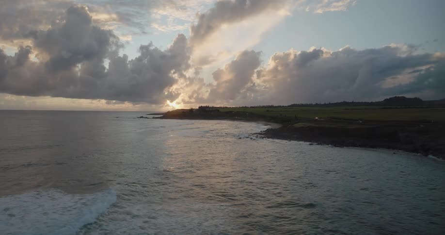 Clouds floating above a coastline at sunset