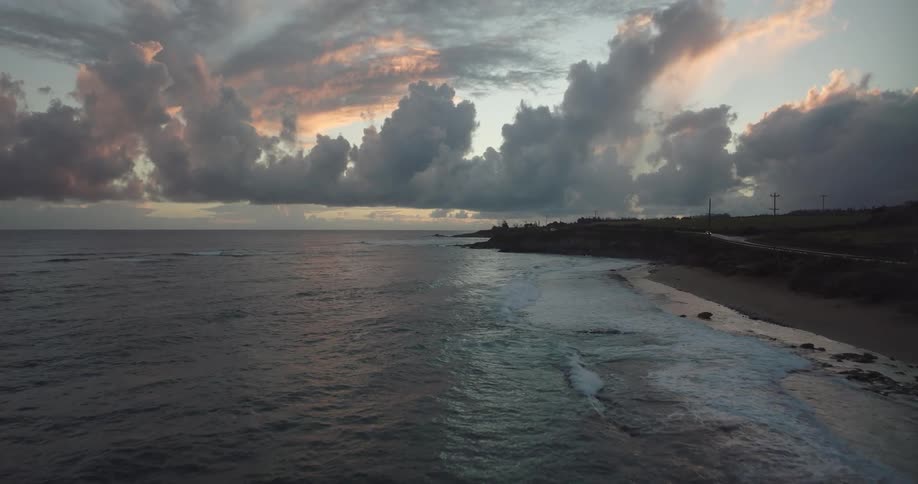 Aerial view of shoreline and highway near the ocean at sunset