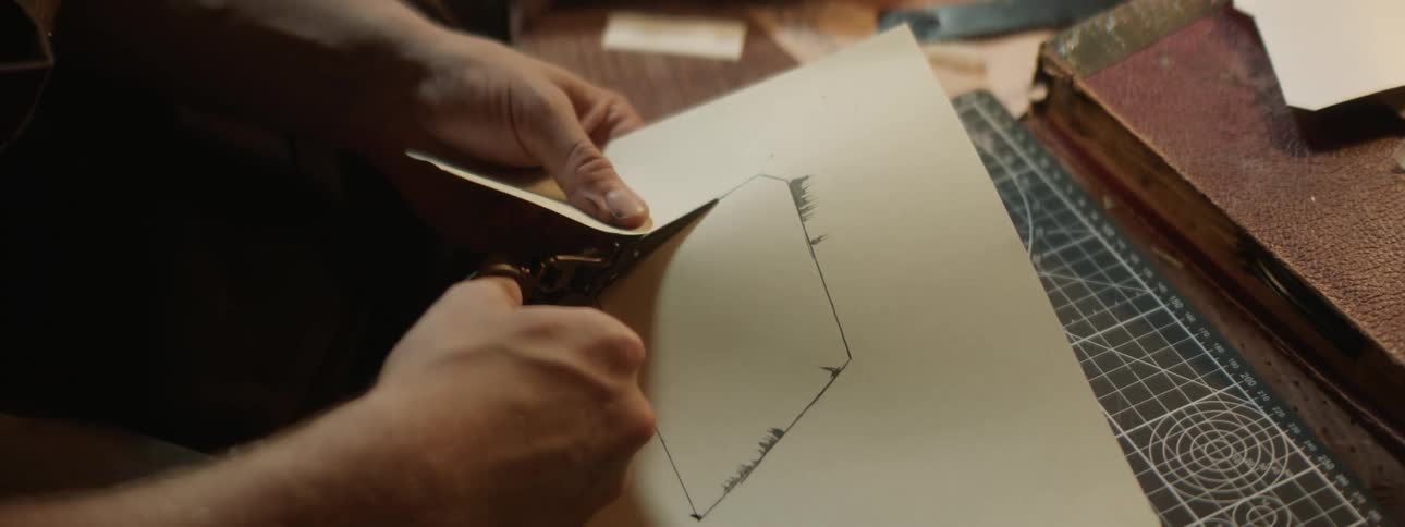 Person cuts shape out of paper with scissors