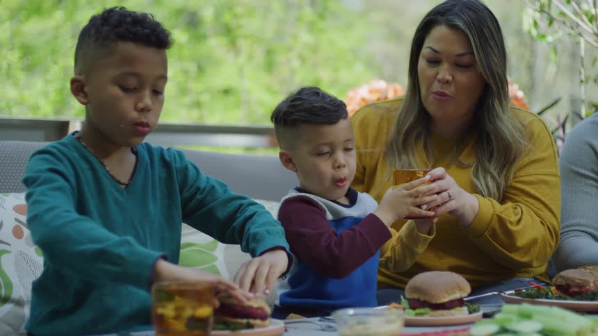 A family eats together at a table during the day
