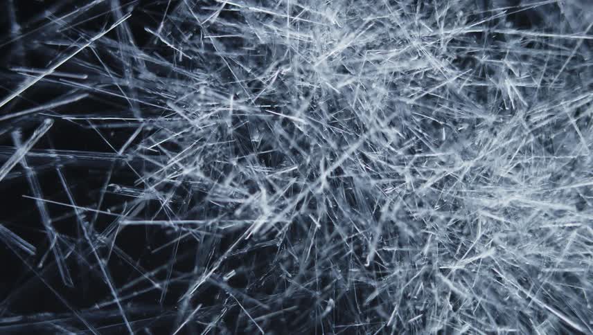 White lines grow and spread like cracks across the darkness