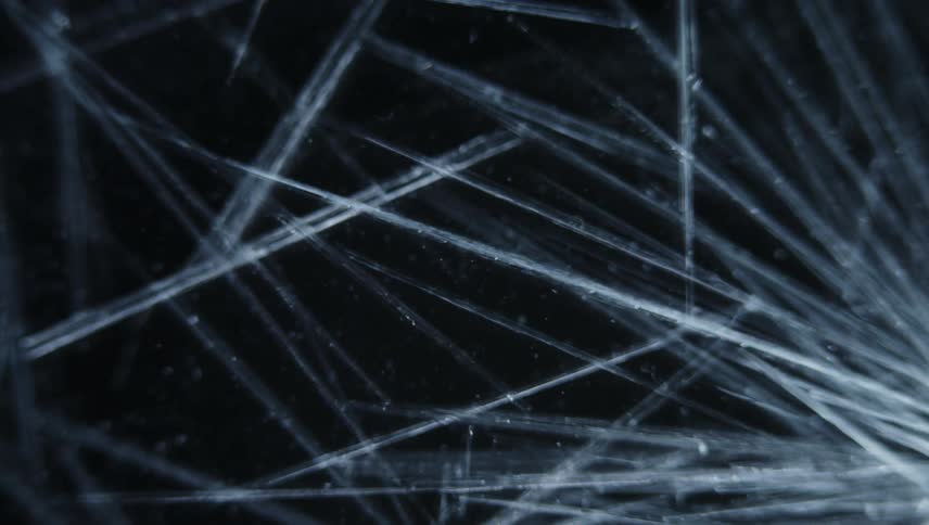 White lines grow and spread like cracks across the darkness