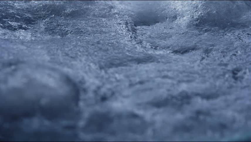 An icy gray surface bubbles and rises