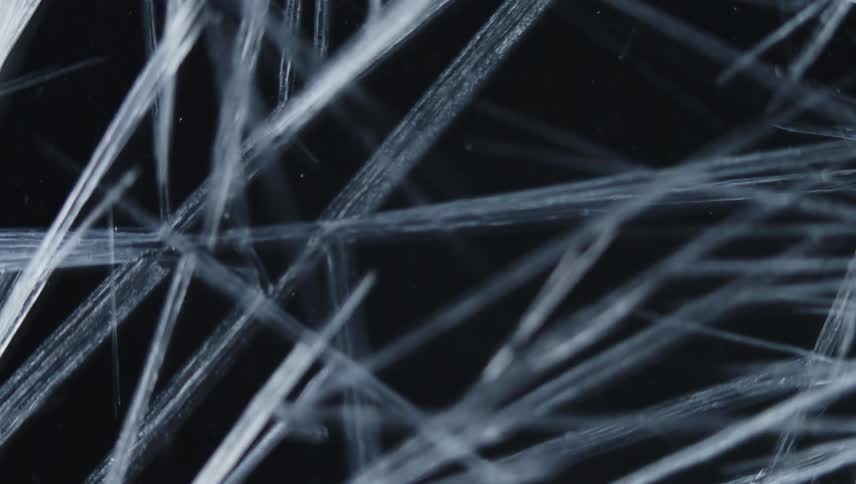 Translucent pale icy crystalline shards multiple and spread against a black background