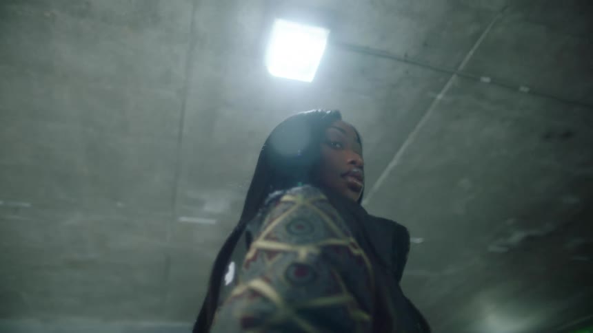 Group of four people wearing thick jackets modeling for the camera under a concrete roof near a garden