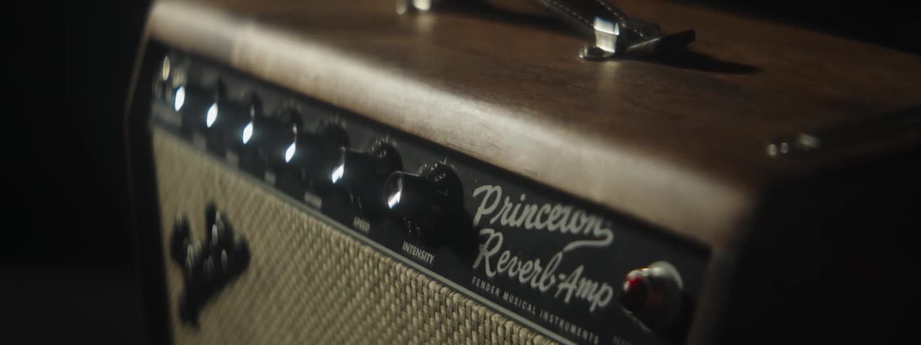 Close up of a vintage guitar amplifier inside a dimly lit room