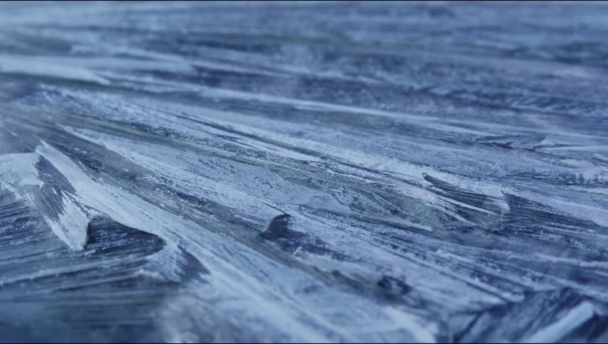 Ice crystals are forming over water shown very close up