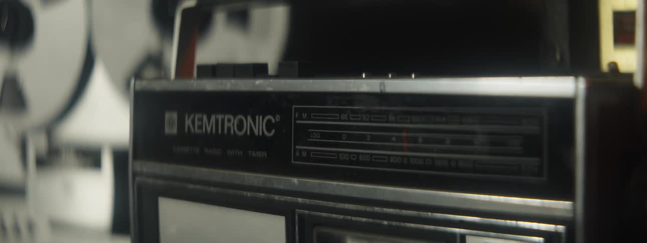 Close up of the dial on a vintage radio cassette on a room surrounded by audio equipment