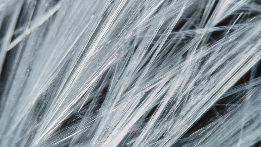 Light shines on strands of organic fiber as they grow in the darkness