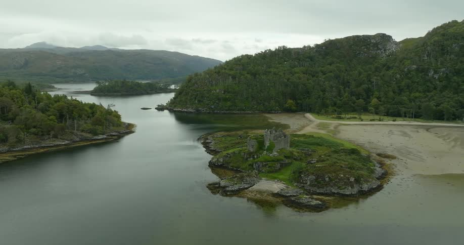 Sea water surrounds a beach and forested land