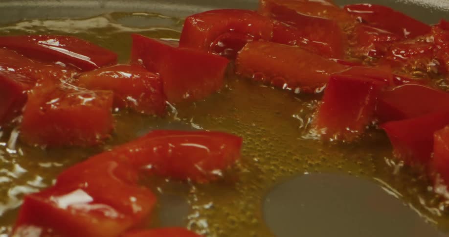 Food slowly slides across a skillet while being cooked in oil