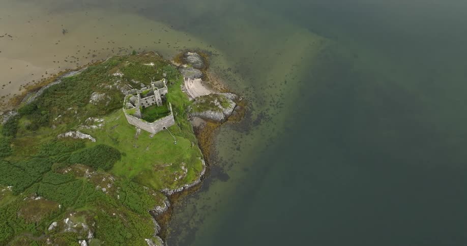 A castle on a headland on the sea during the day