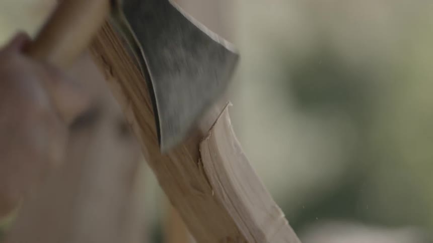 A small hatchet is being used to trim a piece of wood