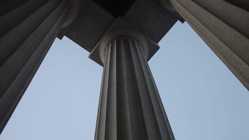 Large stone pillars hold up the roof on a sunny day