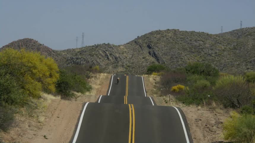 A person riding a bicycle on a hilly road