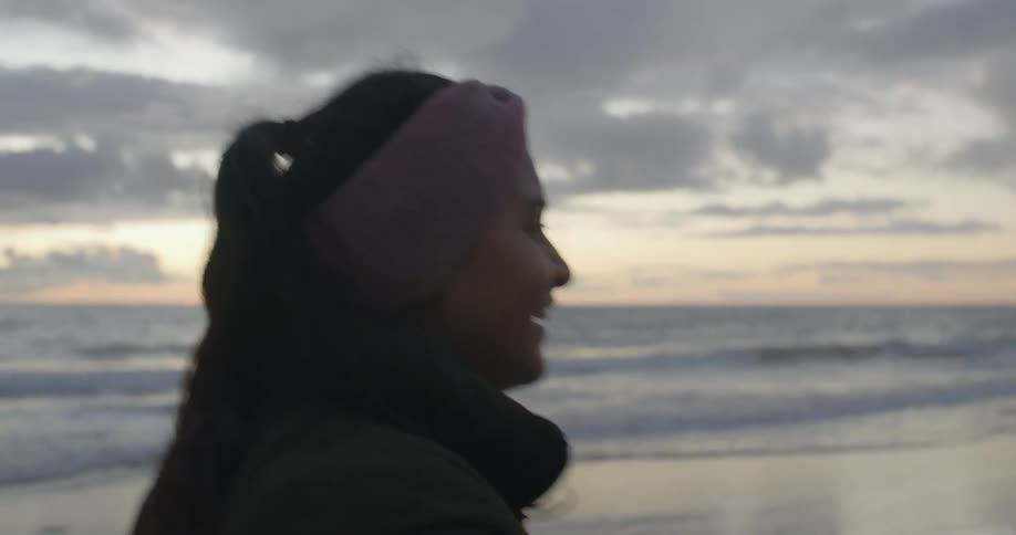 A girl talks while walking on the beach