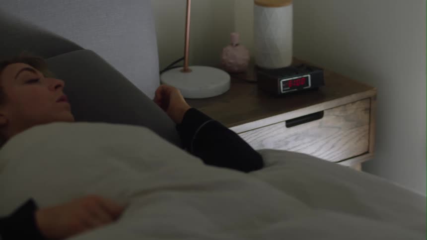 Woman with fair hair and black sweater wakes up in the morning